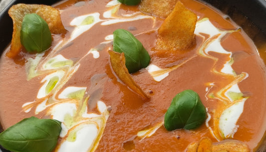 Tomatencremesuppe mit süßer Pflaumen-Note, Basilikumöl & knusprigen Paprika-Chips